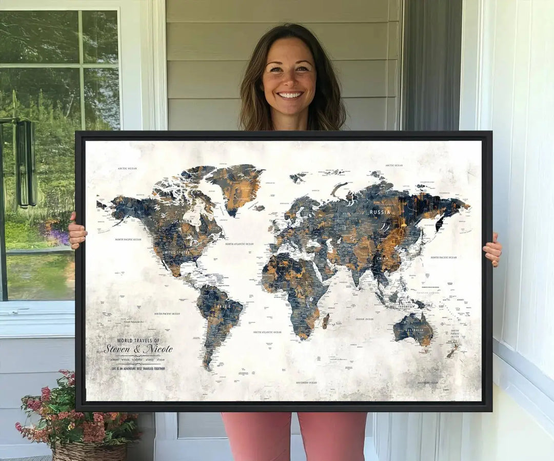 A smiling woman proudly holds the Personalized Push Pin Map Wall Art Print - Detailed Custom World Map Canvas Print in front of a white wall, perfect for travel enthusiasts eager to mark their adventures.